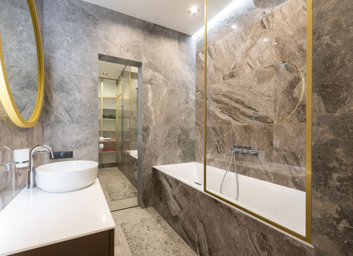 Baño con lavabo, bañera y grifería; fotografía real de referencia