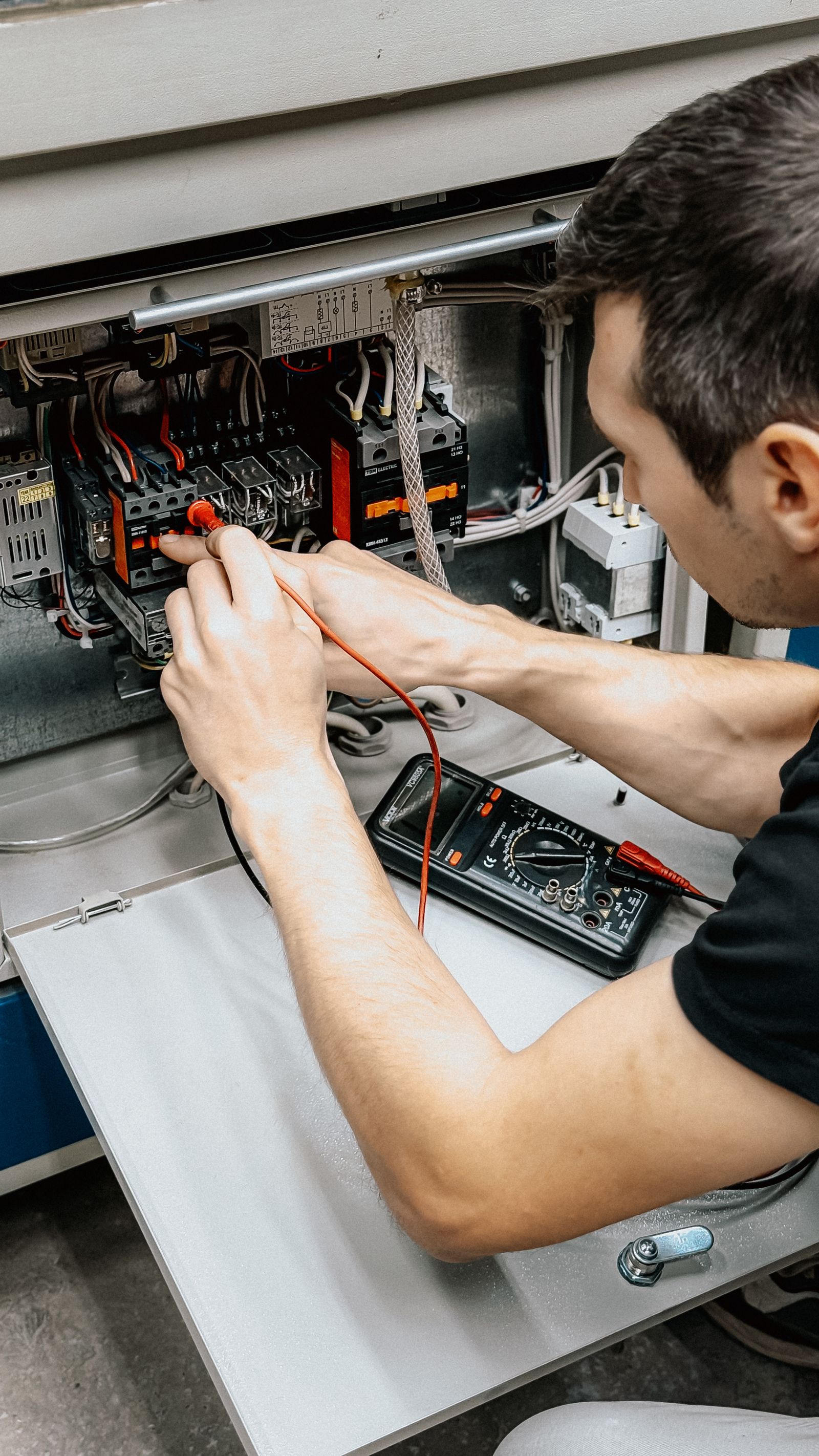 Profesional utilizando un equipo de medición en un cuadro eléctrico